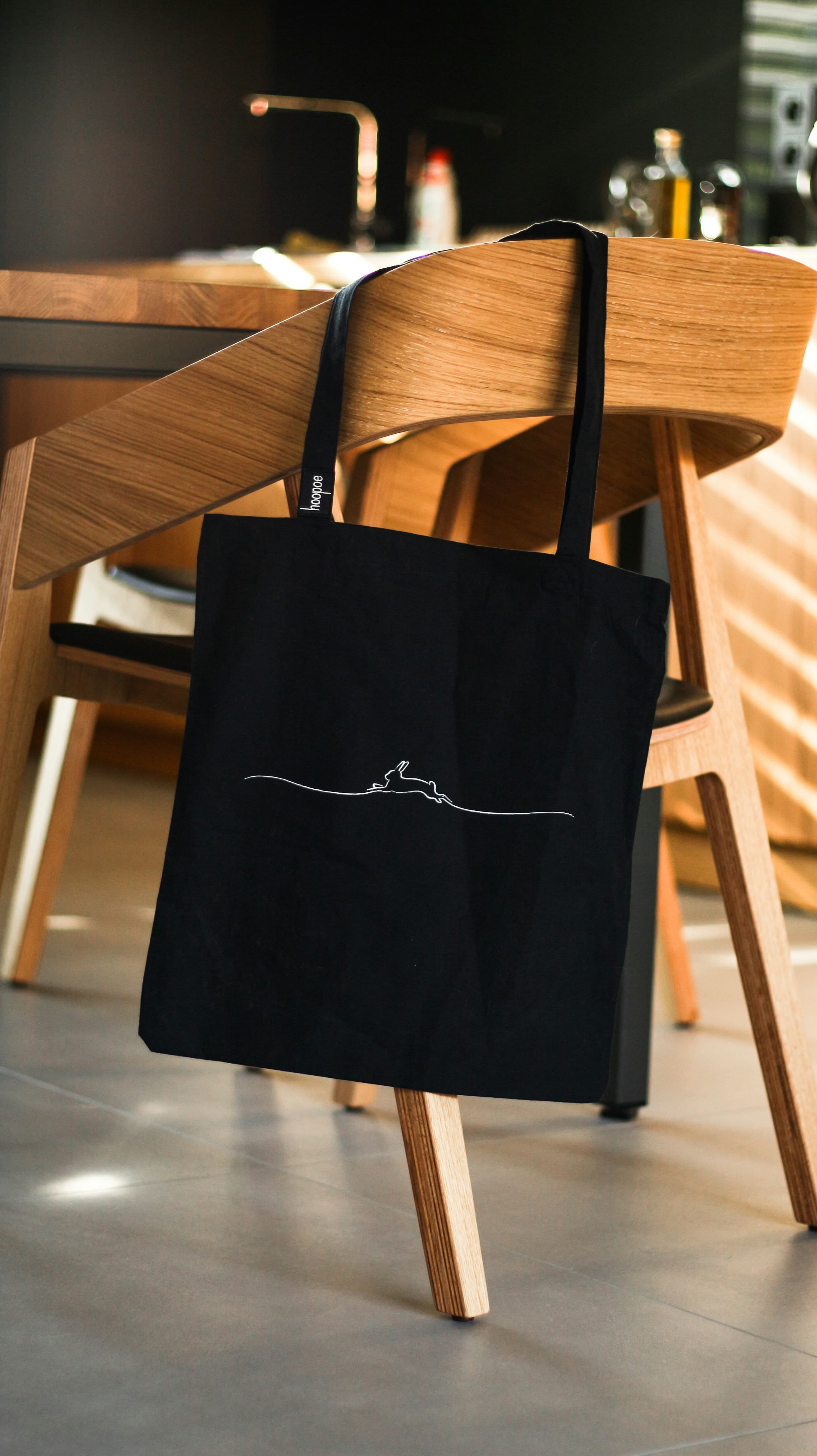 Black canvas tote bag with line-art print